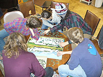 Photo of uoung people doing a jigsaw puzzle.